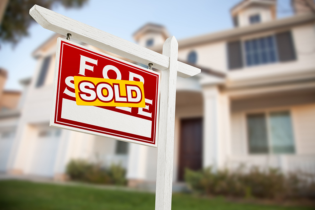 White mansion with sold banner displayed White mansion with sold banner displayed